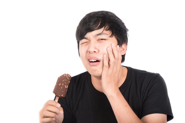 asian-man-eating-ice-cream-with-pain-his-tooth-white-wall_43400-582