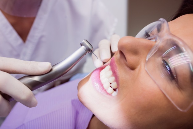 dentist-examining-female-patient_107420-65401