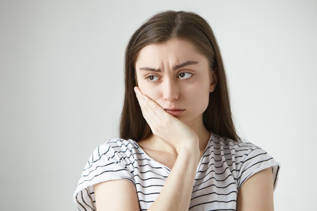 beautiful-unhappy-student-girl-dressed-striped-t-shirt-frowning-keeping-hand-her-cheek-while-suffering-from-toothache-feeling-miserable-helpless-because-terrible-unbearable-pain_343059-1436